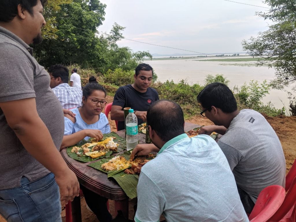 People having food by the river on Picnic Day.